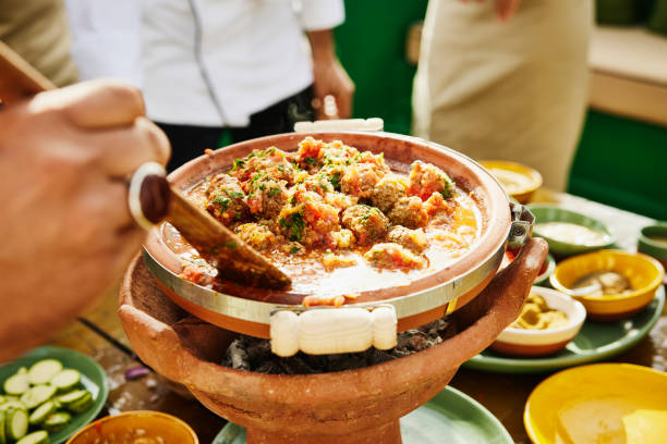 Close up shot of man stirring dish in tajine during Moroccan cooking class